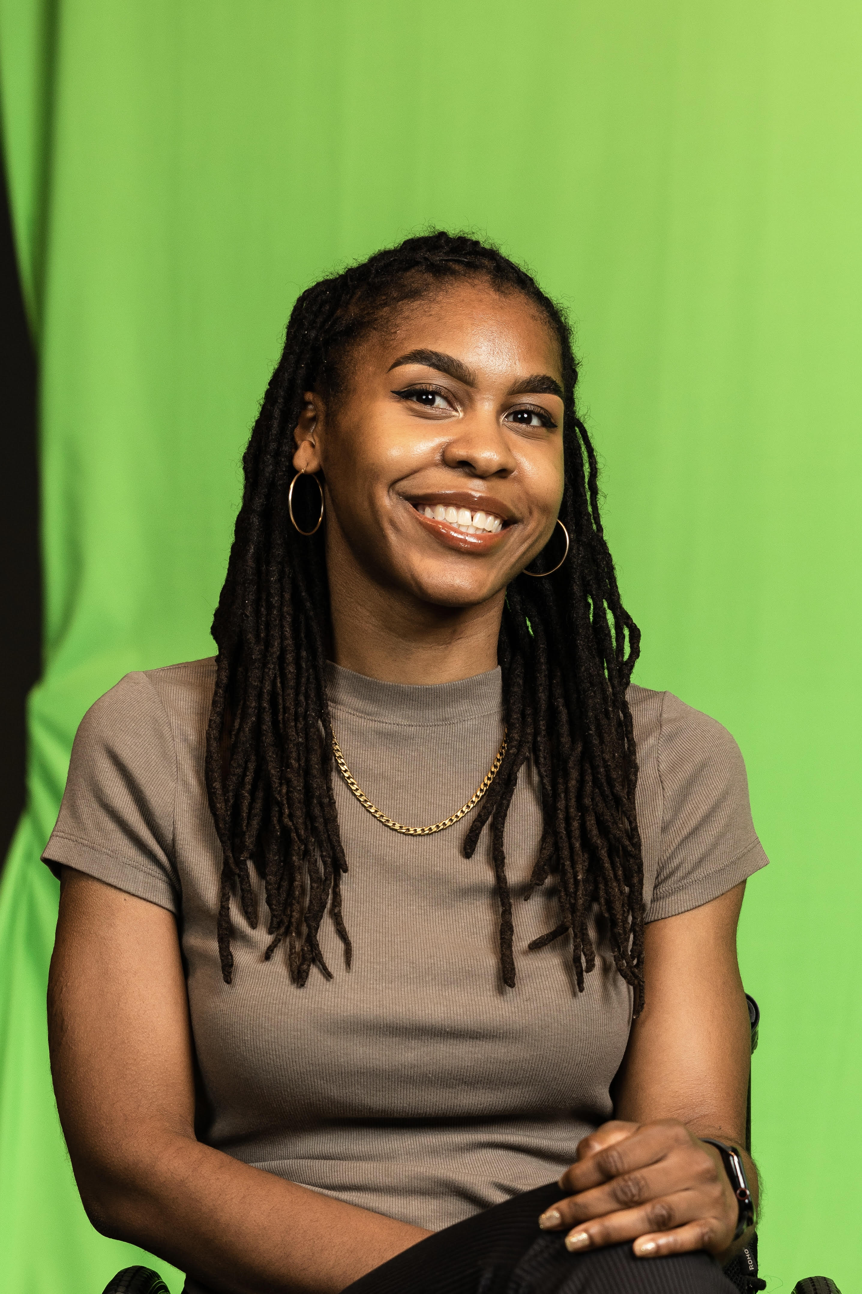 Photo of Tyree Brown smiling in front of a green backdrop