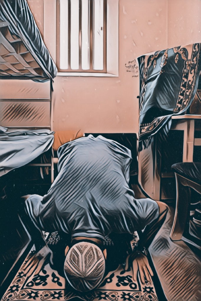 image of man kneeling in prayer in a prison cell